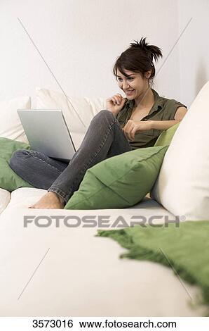 Smiling woman in living room with laptop View Large Photo Image Stock Photograph - Smiling woman in living room with laptop . Fotosearch
