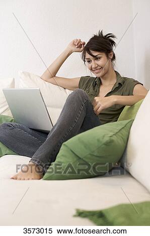 Smiling woman in living room with laptop View Large Photo Image Stock Photography - Smiling woman in living room with laptop . Fotosearch