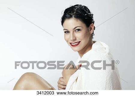 Stock Image - Smiling woman wrapped in a white towel . Fotosearch