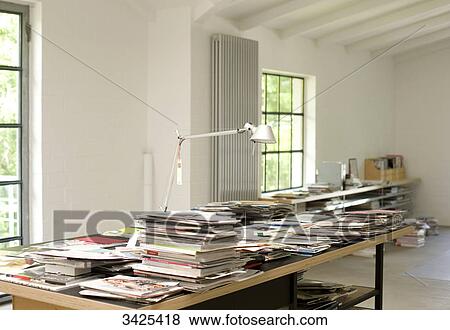 Stacks of magazines and books on a table View Large Photo Image Stock Photo - Stacks of magazines and books on a table . Fotosearch