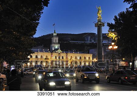 Stock Image - Tavisuplebis Moedani, illuminated townhall in the background, Tbilisi, Georgia . Fotosearch