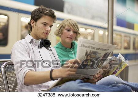 Teenager couple readung newspaper at underground, horizontal format View Large Photo Image Stock Photography - Teenager couple readung newspaper at underground, horizontal format . Fotosearch