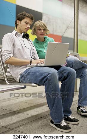 Teenager couple using laptop at underground station, low-angle view View Large Photo Image Stock Image - Teenager couple using laptop at underground station, low-angle view . Fotosearch