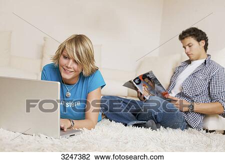 Teenager couple using media in living room, slanted view View Large Photo Image Stock Image - Teenager couple using media in living room, slanted view . Fotosearch
