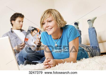 Teenager couple using media in living room, slanted view View Large Photo Image Stock Photo - Teenager couple using media in living room, slanted view . Fotosearch