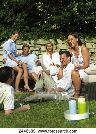 Stock Image - Three couples celebrating garden party . Fotosearch