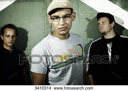 Three young men standing in front of a gate, portrait View Large Photo Image Picture - Three young men standing in front of a gate, portrait . Fotosearch