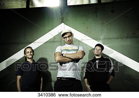 Three young men standing in front of a gate, portrait View Large Photo Image Stock Photograph - Three young men standing in front of a gate, portrait . Fotosearch