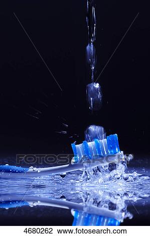 Stock Image - Tooth brush surrounded by water . Fotosearch