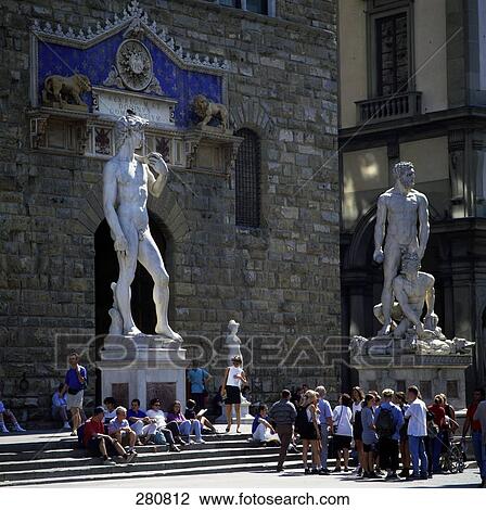 Stock Image - Tourist watching Michelangelo's statue David in front of town hall, Piazza Della Signoria, Florence, Tuscany, Italy . Fotosearch