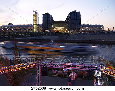 Stock Photo - Tourists looking at tour boat sailing in river . Fotosearch