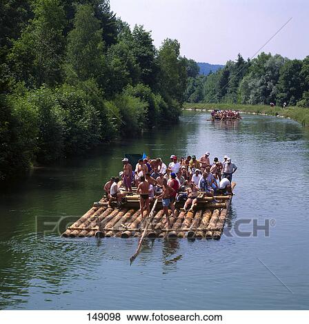 Stock Photo - Tourists on log rafts in river, Isar River, Munich, Germany . Fotosearch