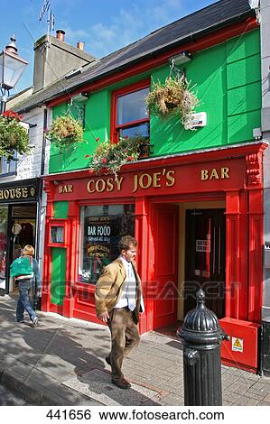 Stock Photograph - Two people walking in front of bar on street, Bridge Street, Republic of Ireland . Fotosearch