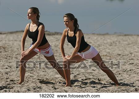 Two young women doing yoga on lake beach View Large Photo Image Stock Image - Two young women doing yoga on lake beach . Fotosearch