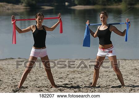 Two young women doing yoga on lake beach  View Large Photo Image Stock Photo - Two young women doing yoga on lake beach . Fotosearch