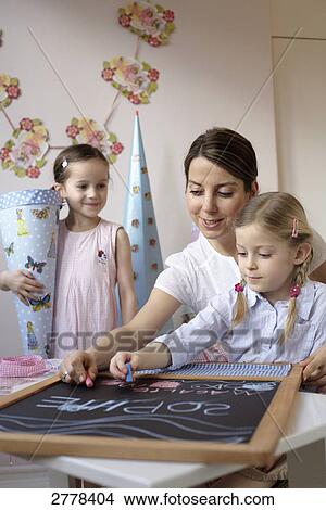 Picture - Woman and her daughter writing on chalkboard . Fotosearch