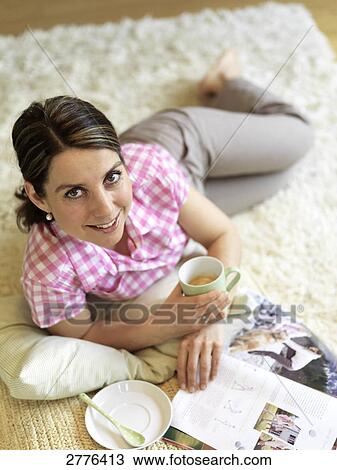 Stock Image - woman drinking some tea, elevated view . Fotosearch
