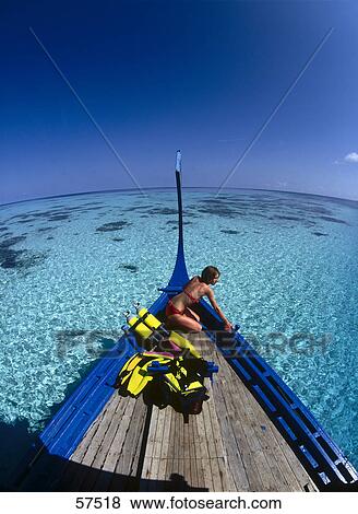 Stock Photo - Woman in a boat with scuba diving gears, Maldives . Fotosearch