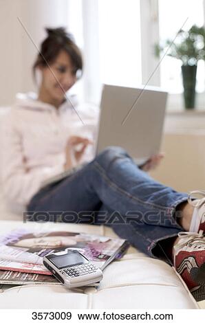 Woman in living room using laptop View Large Photo Image Stock Photo - Woman in living room using laptop . Fotosearch