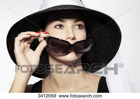 Woman with black hat holding sunglasses View Large Photo Image Stock Photo - Woman with black hat holding sunglasses . Fotosearch