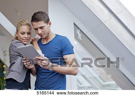 Young couple with ipad View Large Photo Image Picture - Young couple with ipad . Fotosearch