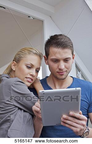 Stock Photo - Young couple with ipad . Fotosearch