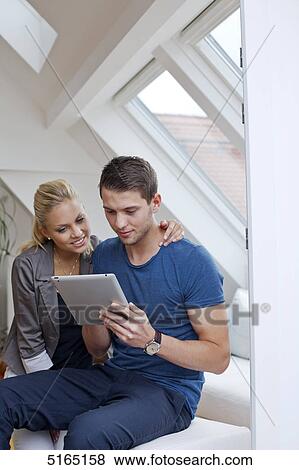 Stock Photo - Young couple with ipad . Fotosearch