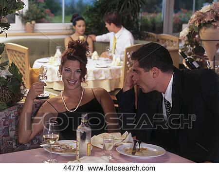 Young man looking at young woman smiling in restaurant View Large Photo Image Stock Photo - Young man looking at young woman smiling in restaurant . Fotosearch