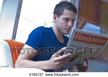 Young man reading newspaper View Large Photo Image Stock Photo - Young man reading newspaper . Fotosearch