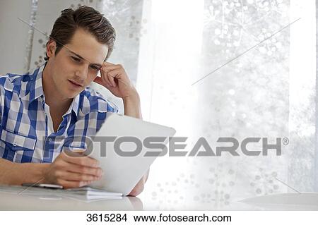 Picture - Young man using iPad . Fotosearch