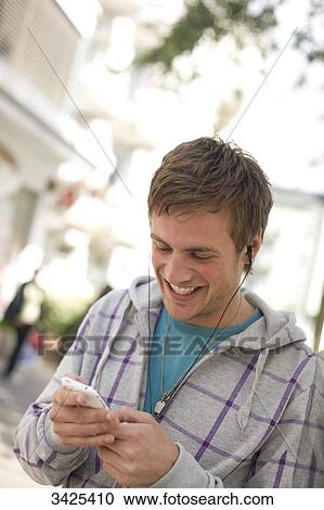 Young man using mp3-player, low angle view View Large Photo Image Stock Image - Young man using mp3-player, low angle view . Fotosearch