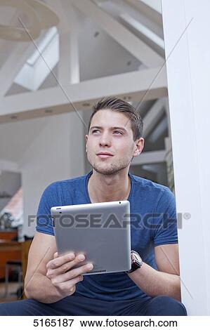 Young man with ipad View Large Photo Image Stock Photo - Young man with ipad . Fotosearch