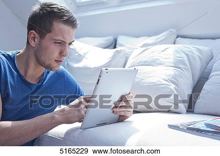Stock Photo - Young man with ipad . Fotosearch