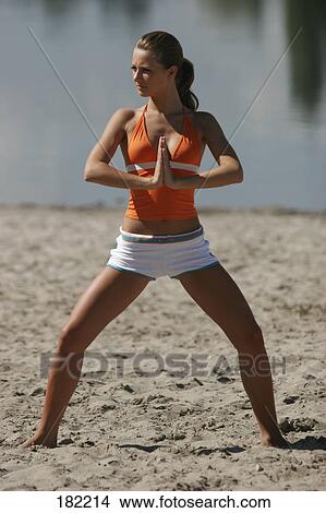 Young woman doing yoga on lake beach View Large Photo Image Picture - Young woman doing yoga on lake beach . Fotosearch