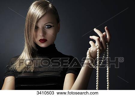 Young woman holding pearl necklace in her hand View Large Photo Image Stock Image - Young woman holding pearl necklace in her hand . Fotosearch