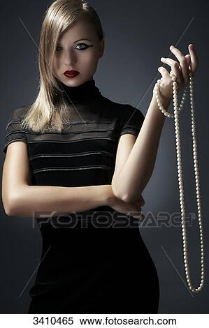 Stock Photography - Young woman holding pearl necklace in her hand . Fotosearch