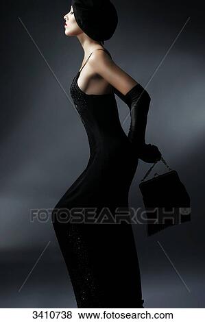 Stock Photo - Young woman in black dress with hat, handbag and gloves . Fotosearch