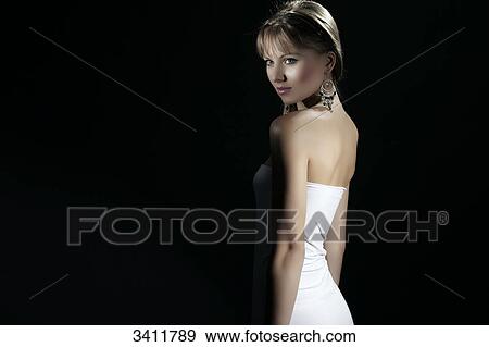 Young woman in white dress in front of black background View Large Photo Image Stock Photo - Young woman in white dress in front of black background . Fotosearch