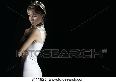 Young woman in white dress in front of black background View Large Photo Image Stock Photography - Young woman in white dress in front of black background . Fotosearch