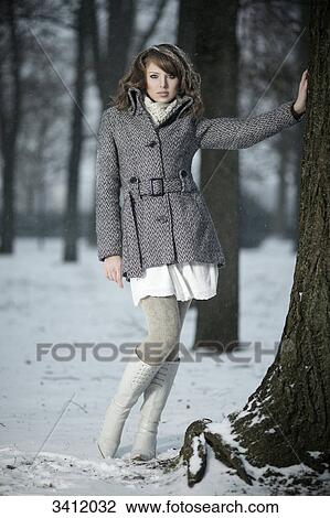 Young woman leaning against tree View Large Photo Image Stock Image - Young woman leaning against tree . Fotosearch