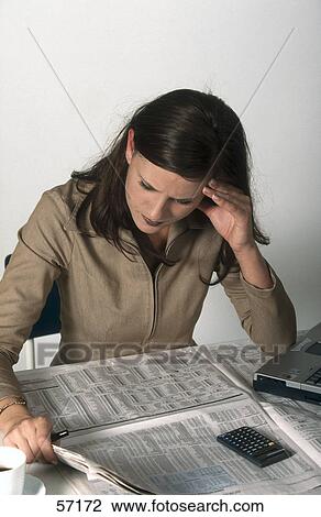 Stock Image - Young woman reading newspaper . Fotosearch
