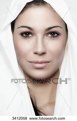 Stock Photo - Young woman shrouded in white cloth, portrait . Fotosearch