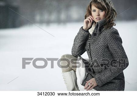 Young woman squatting in snow View Large Photo Image Stock Image - Young woman squatting in snow . Fotosearch