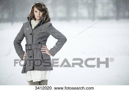 Young woman standing with hands on hips in snow View Large Photo Image Stock Image - Young woman standing with hands on hips in snow . Fotosearch
