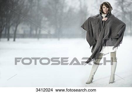 Young woman standing with poncho in snow View Large Photo Image Picture - Young woman standing with poncho in snow . Fotosearch