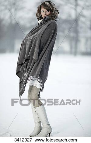 Young woman standing with poncho in snow View Large Photo Image Stock Photo - Young woman standing with poncho in snow . Fotosearch