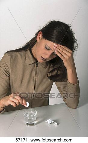 Young woman suffering from headache and putting pill in water glass View Large Photo Image Stock Image - Young woman suffering from headache and putting pill in water glass . Fotosearch