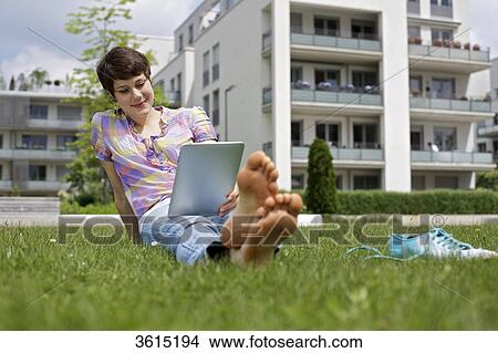 Young woman using iPad in grass View Large Photo Image Picture - Young woman using iPad in grass . Fotosearch