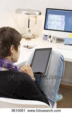 Stock Image - Young woman using iPad . Fotosearch