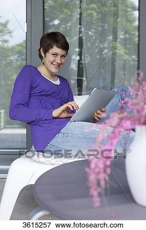 Young woman using iPad View Large Photo Image Stock Photo - Young woman using iPad . Fotosearch